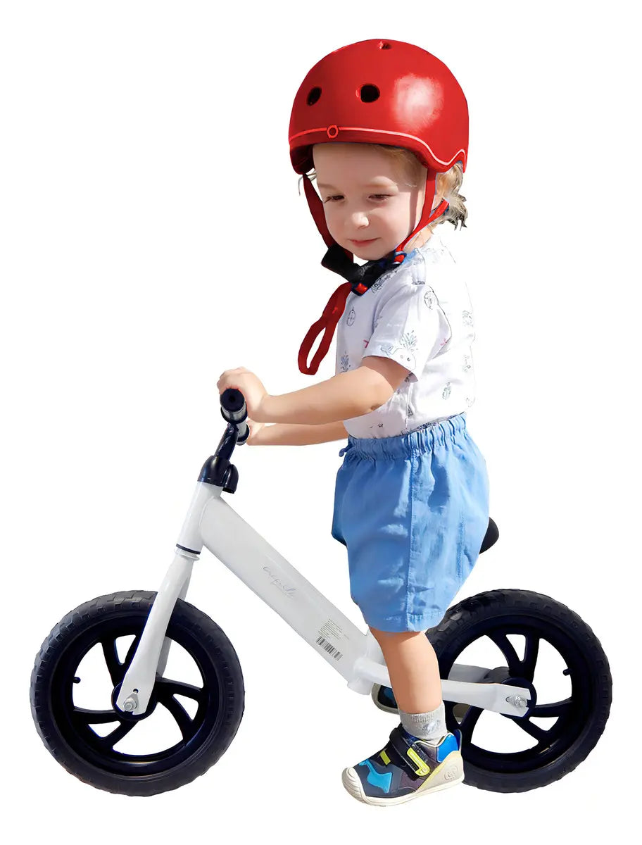 Niño montando bicicleta de equilibrio sin pedales con casco